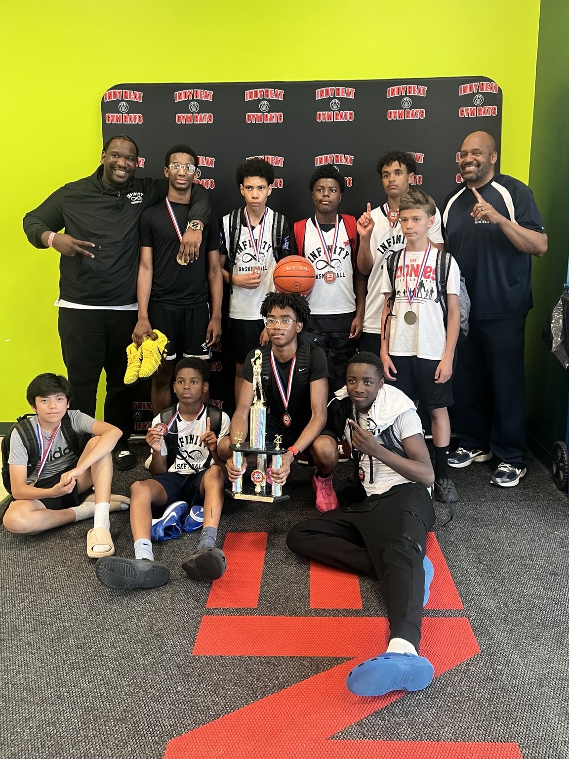 Team Infinity boys players and coaches pose together after tournament competition.