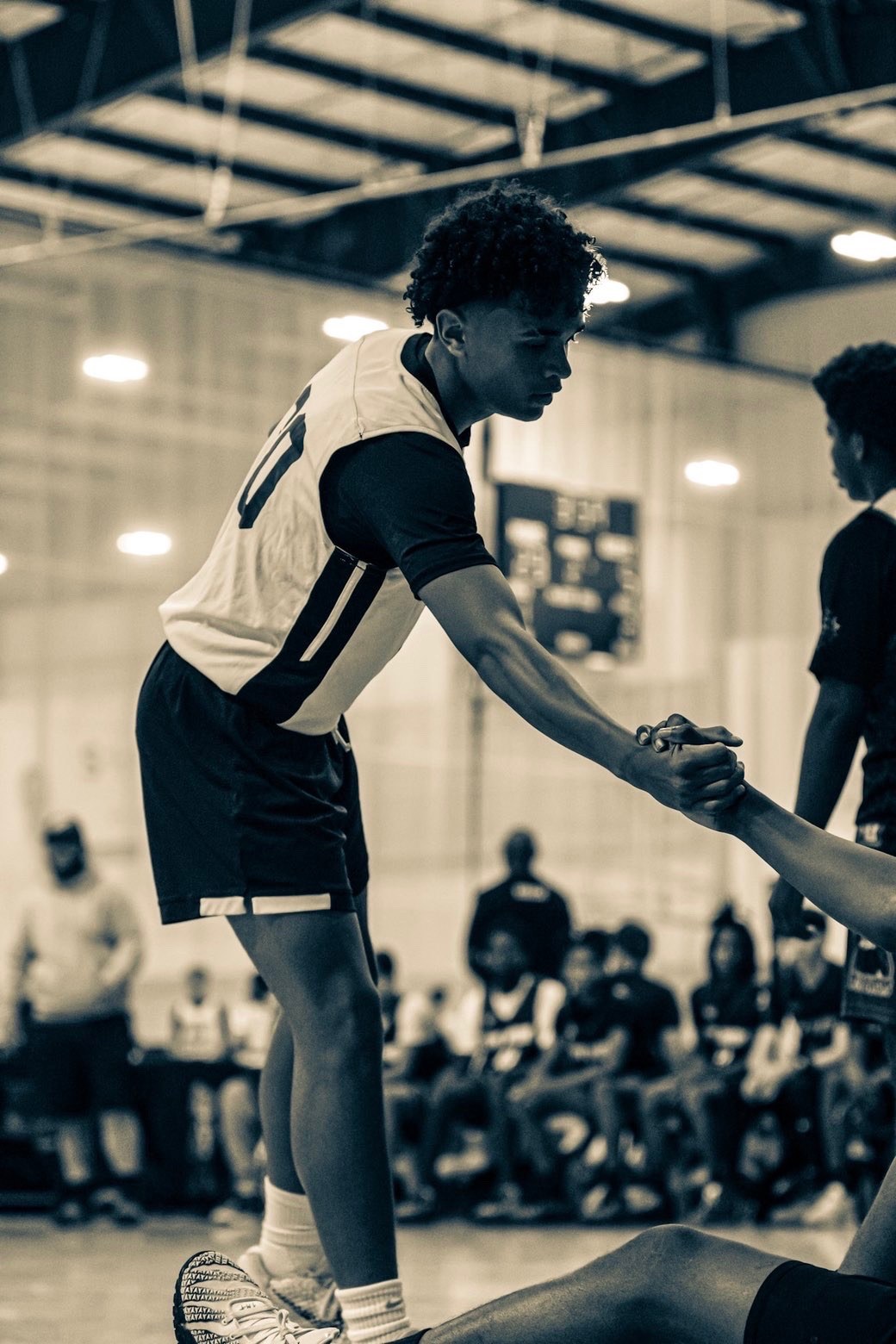 A Team Infinity boys player reaches down to help a teammate up from the court.