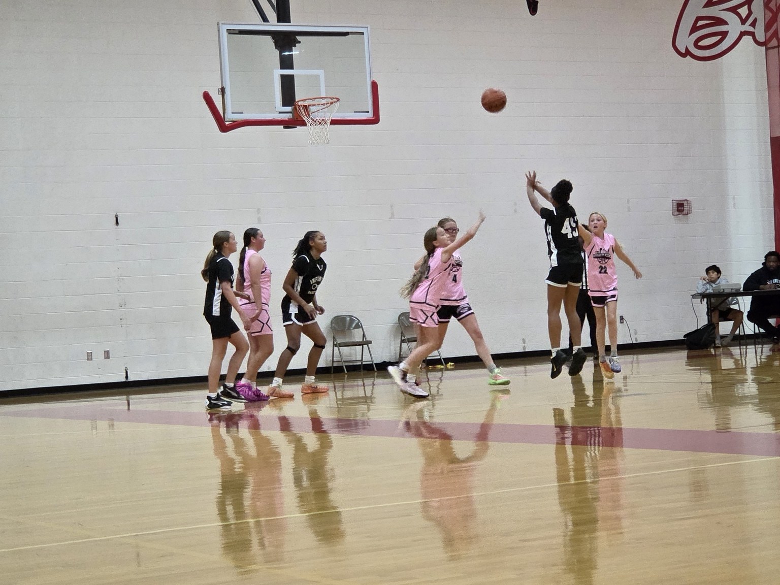 A Team Infinity girls player rises for a jump shot during game action.